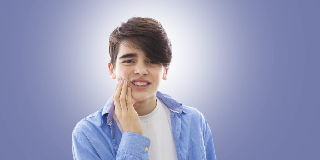 teenage boy with tooth or mouth pain